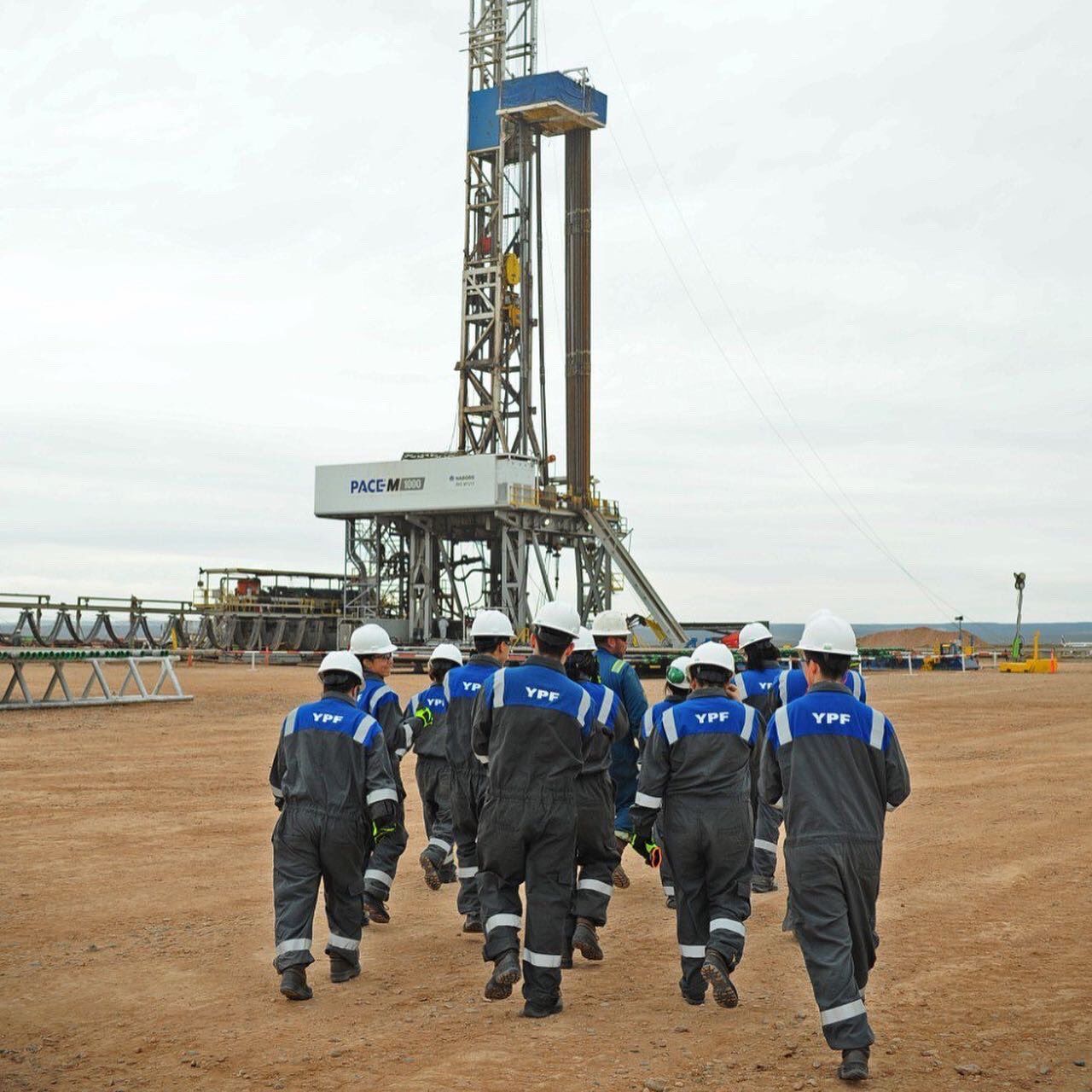 Trabajadores de la industria energética frente a un equipo de perforación en Neuquén